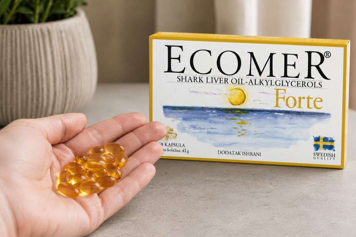 osoba drži kapsule ecomer forte-a u ruci i ecomer stoji na stolu